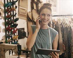 Small business woman in her shop on the phone.