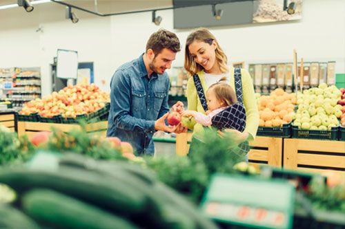 Parents shopping for produce with their baby.